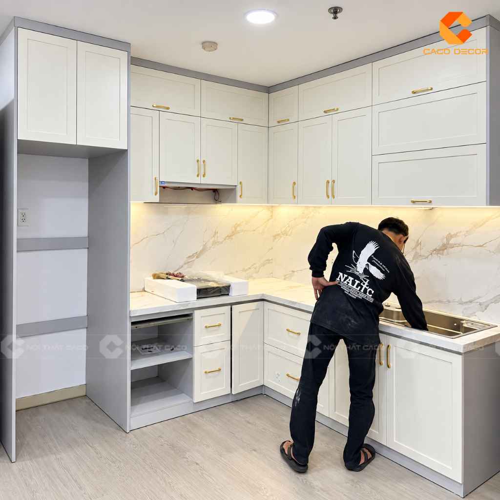 Thợ thi công CaCo tỉ mỉ lắp đặt tủ bếp chữ L