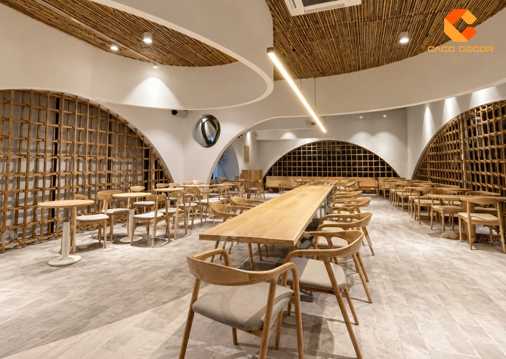 Không gian quán cafe rộng với bàn dài và ghế gỗ bố trí đồng bộ