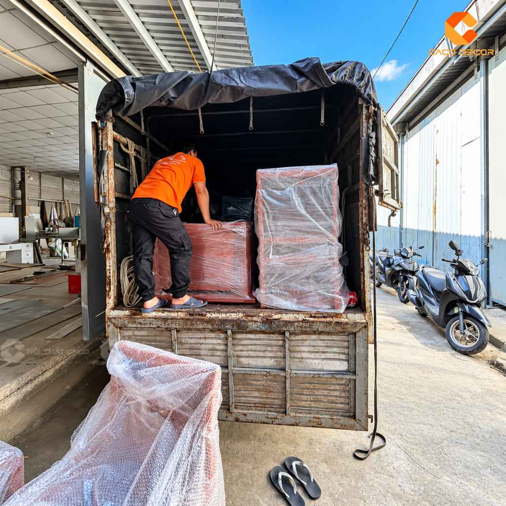 Đội thợ CaCo đưa bàn ghế phòng họp đã đóng gói lên xe vận chuyển
