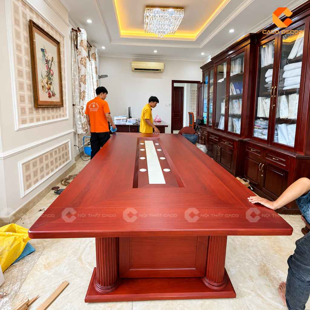Nhân viên CaCo vệ sinh mặt bàn phòng họp gỗ gõ đỏ trước khi bàn giao